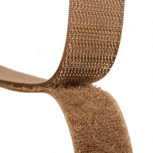 Close-up of a light brown hook-and-loop fastening strap on a plain white background.
